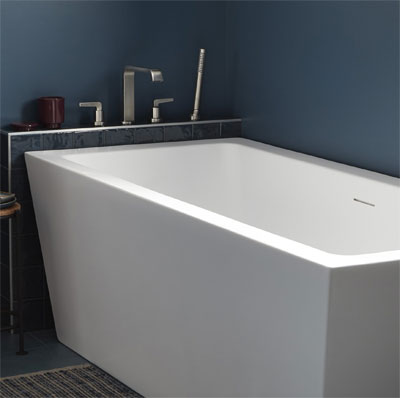 White bathtub in the corner of the blue room.